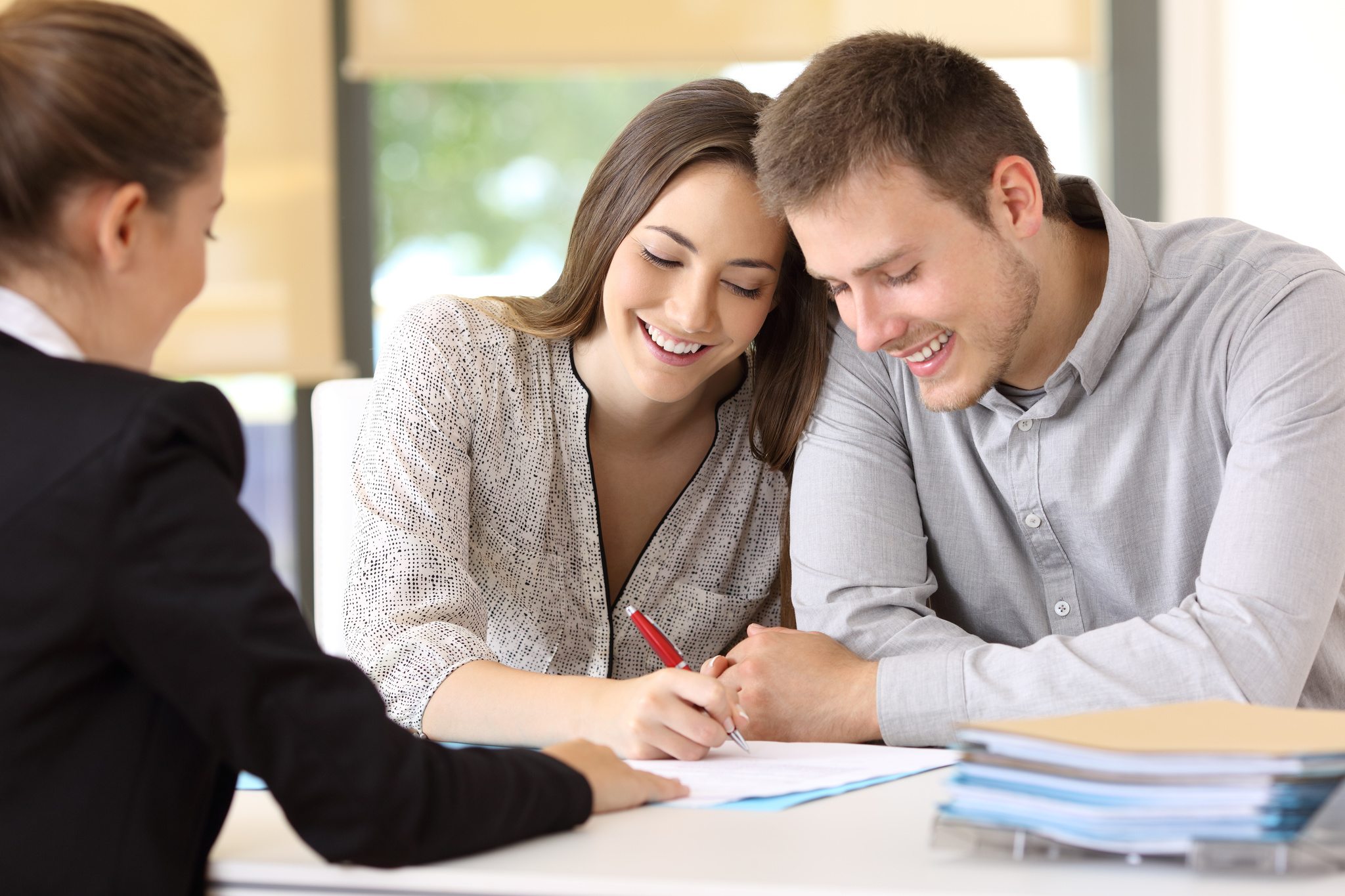 Happy couple signing a contract together