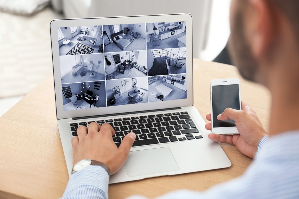 Millennial man looks at Security Camera on Laptop