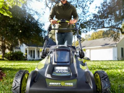 Man walking behind cordless lawn mower