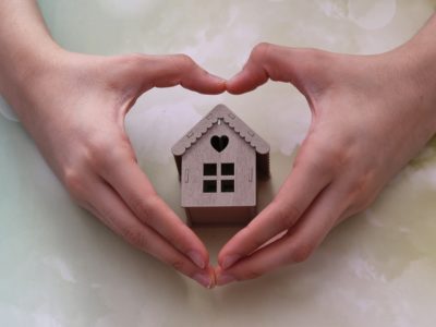 model house inside heart-shaped hands