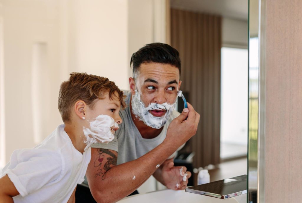 Dad and son in bathroom shaving