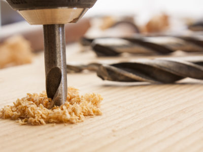 drilled hole with saw dust on wood table