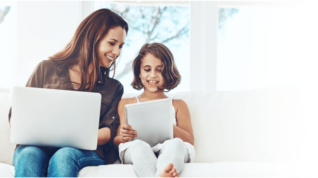 Mom and child on a couch, each using a computer.