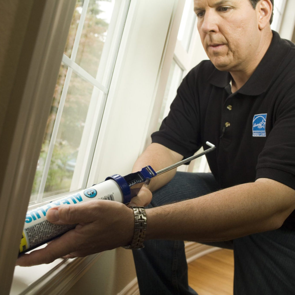 Man caulking a window