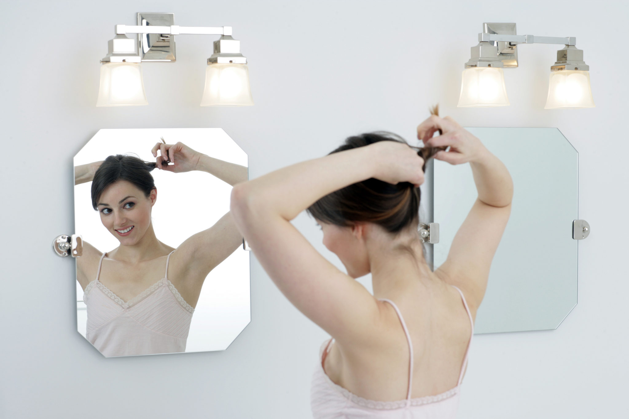 Bright bathroom with woman looking in mirror