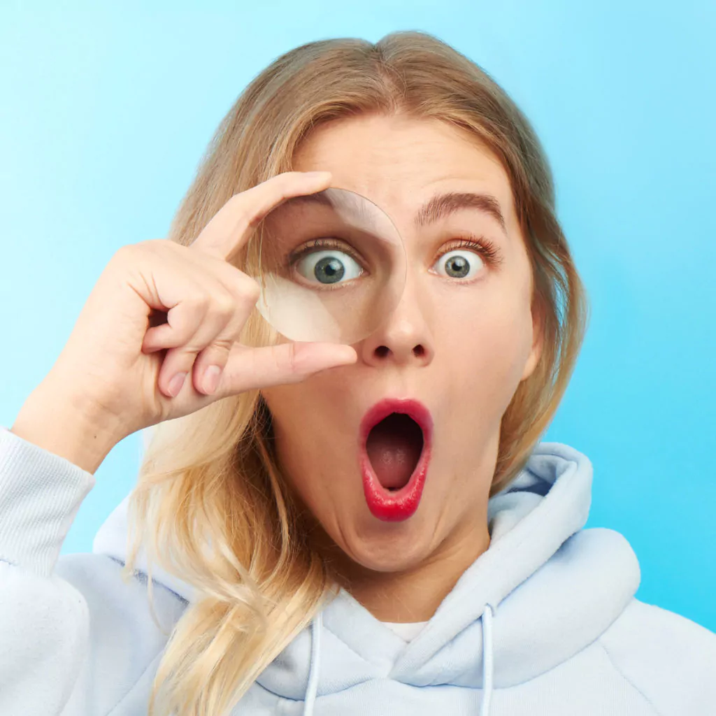 Woman looking at the camera through magnifier