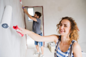 Young couple painting walls in their house