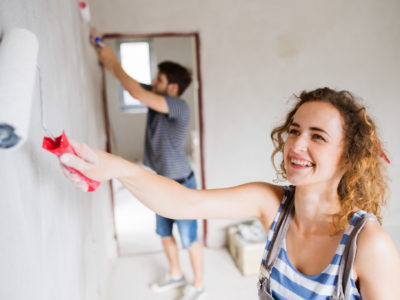 Young couple painting walls in their house