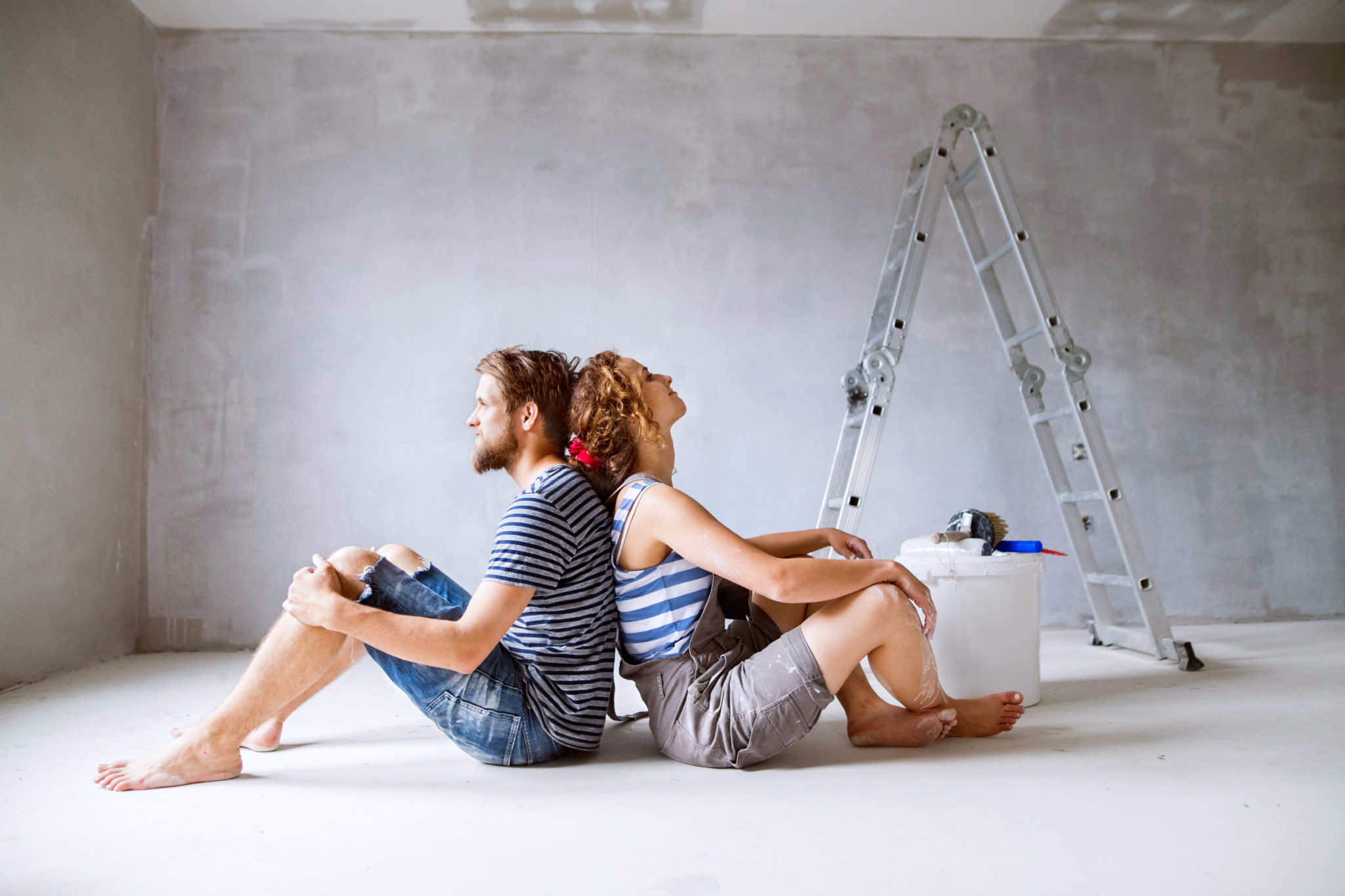 Millennial couple painting walls in their new house