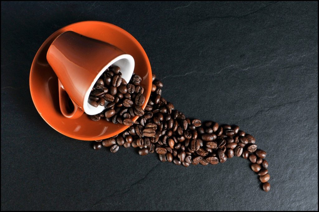 Coffee beans in orange ceramic mug