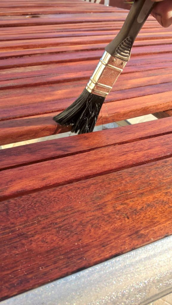 Brush applying wood stain 