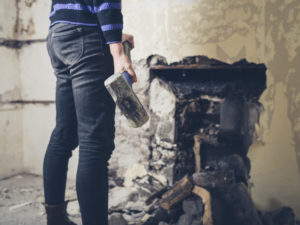 Woman destroying wall with sledgehammer