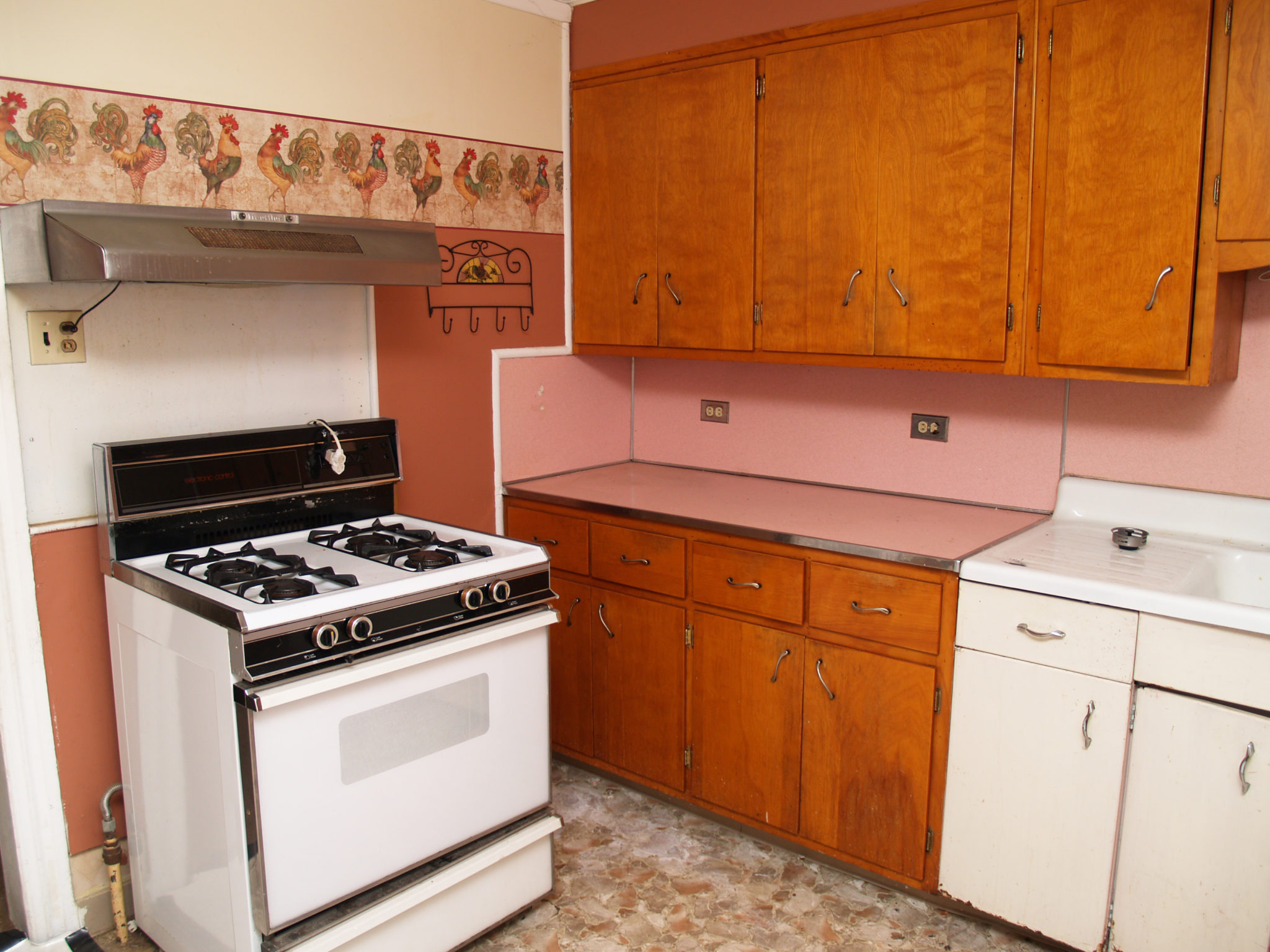 Old kitchen with pink backsplash and wallpaper border