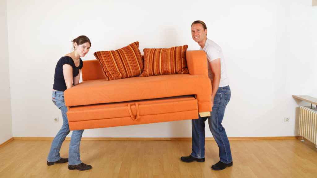 Young couple moving couch.