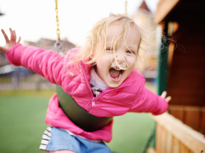 Child playing on backyard swings