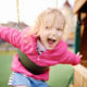 Child playing on backyard swings