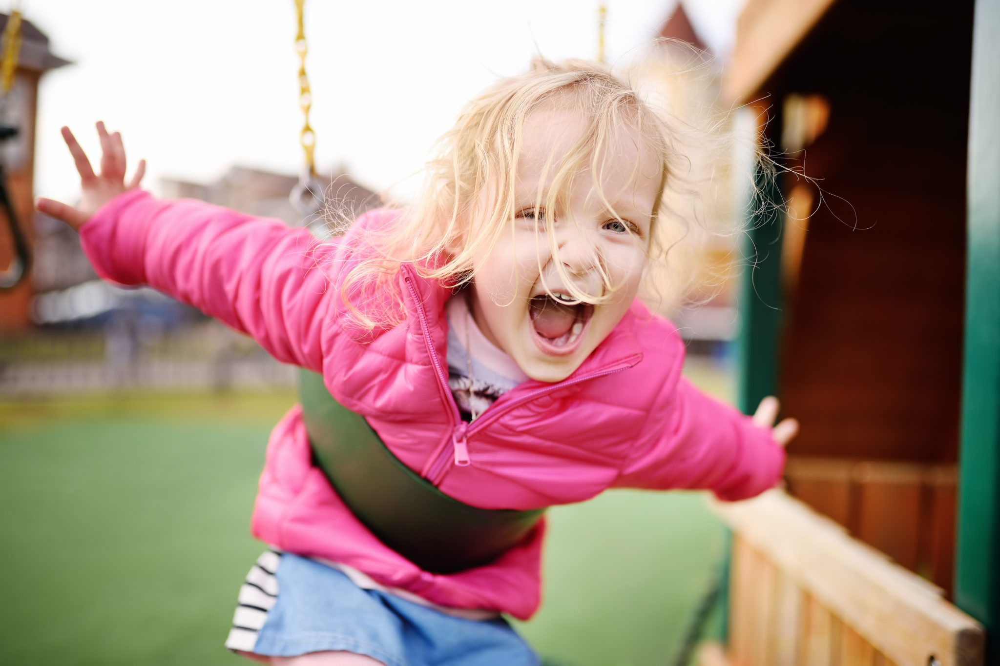 Child playing on backyard swings