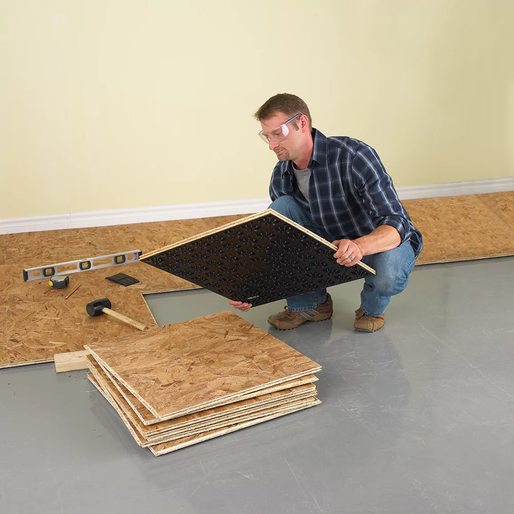 Man installing DRICORE basement flooring