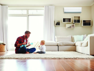 Father playing with young son in air conditioned room