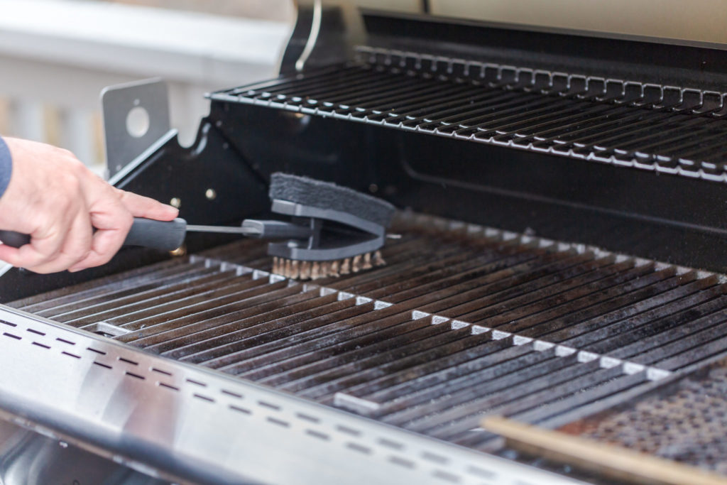 Man cleaning gas grill