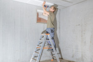 Man installing basement ceiling.
