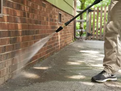 Man pressure washing siding