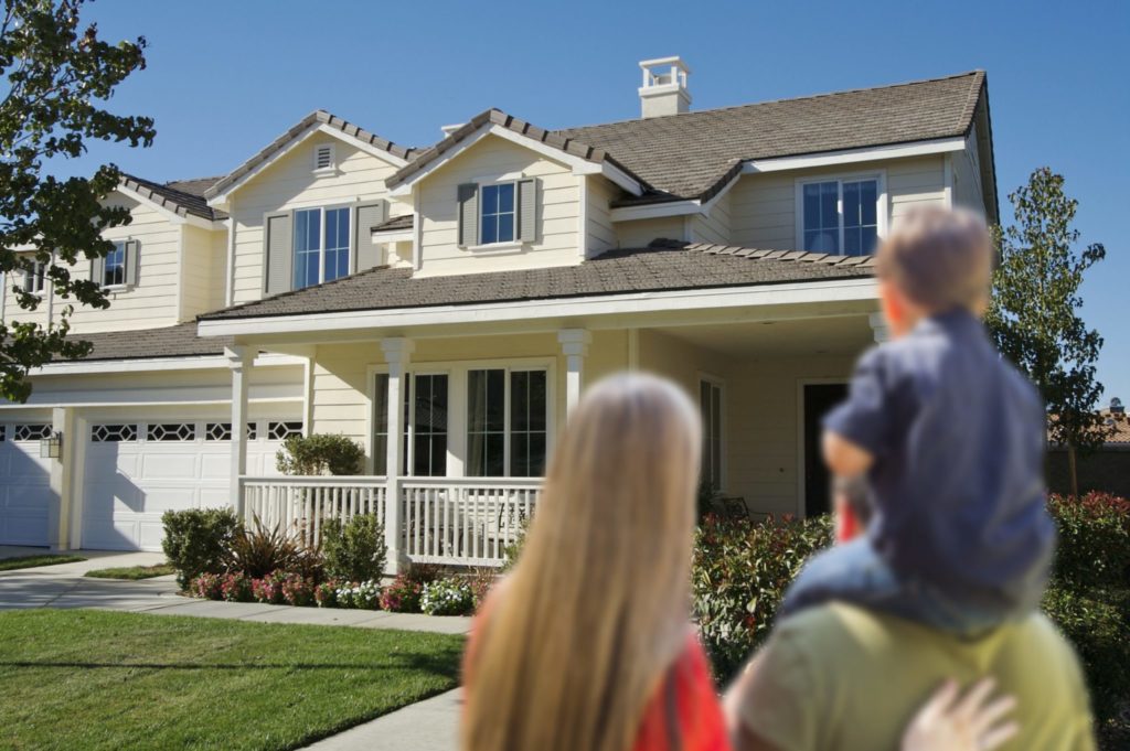 Young Family Looking at a Beautiful New Home.