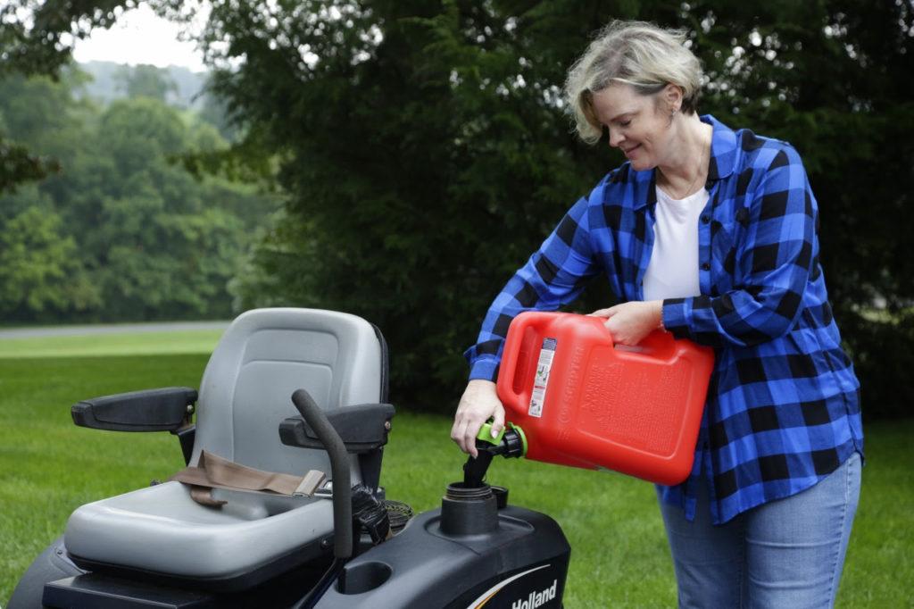 Woman adding gas to a mower