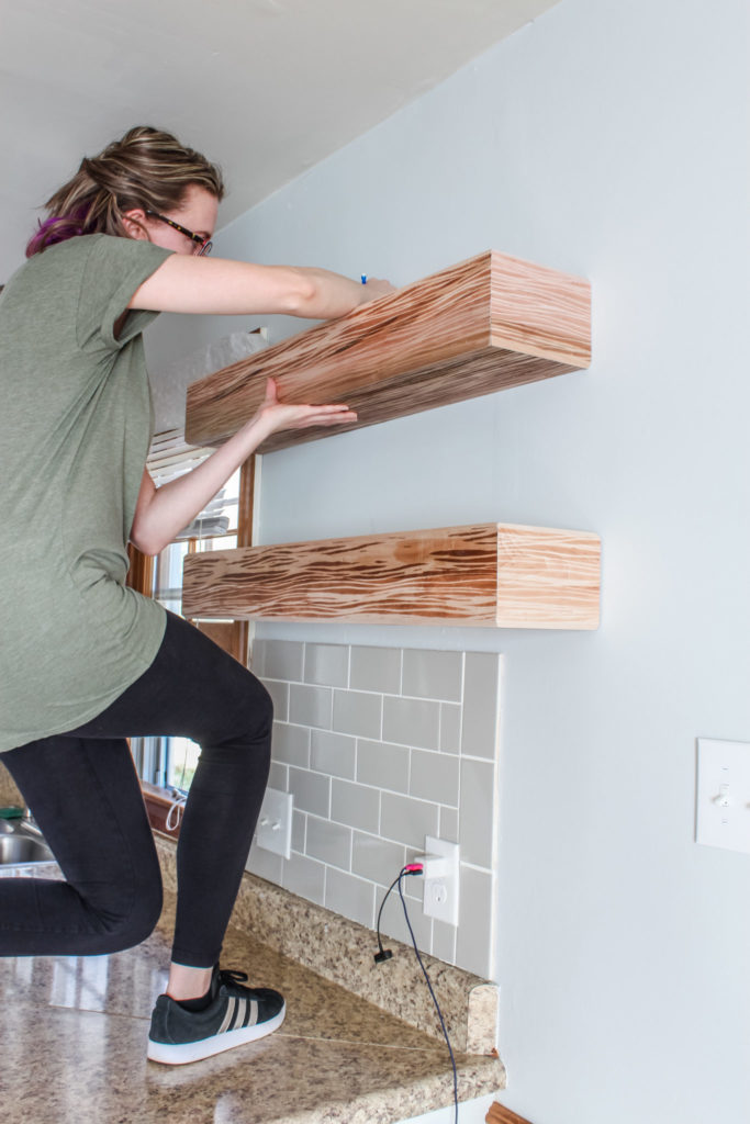 Woman installing a floating shelf