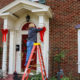 Woman on ladder putting Christmas decorations up