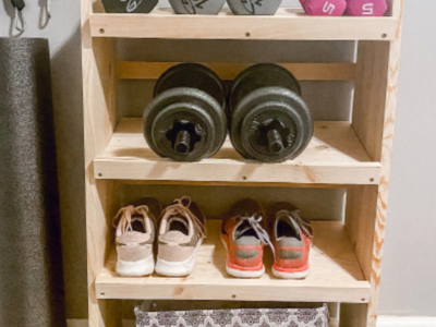 Fitness shelf with shoes, weights and a basket.