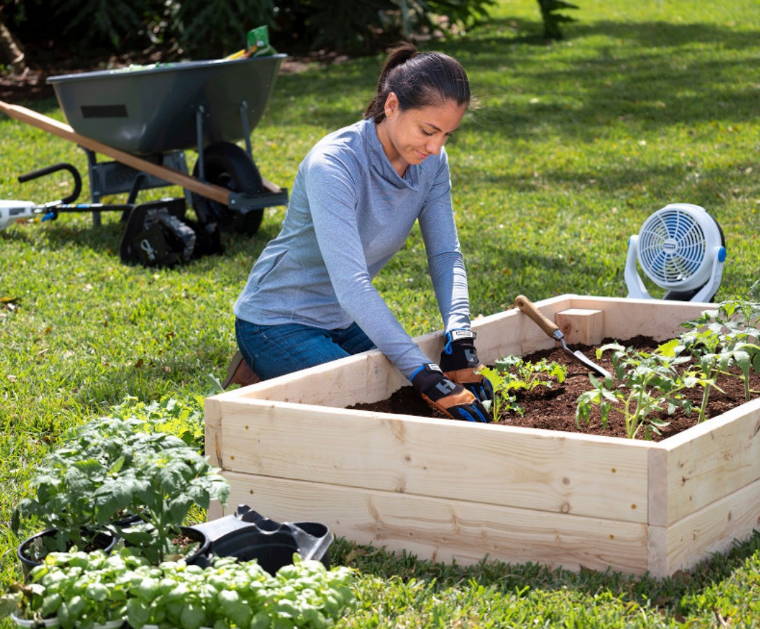 Woman planting in a raised garden bed