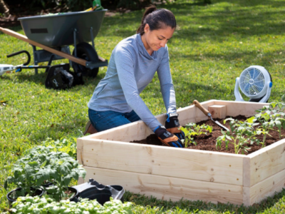 Woman planting in a raised garden bed