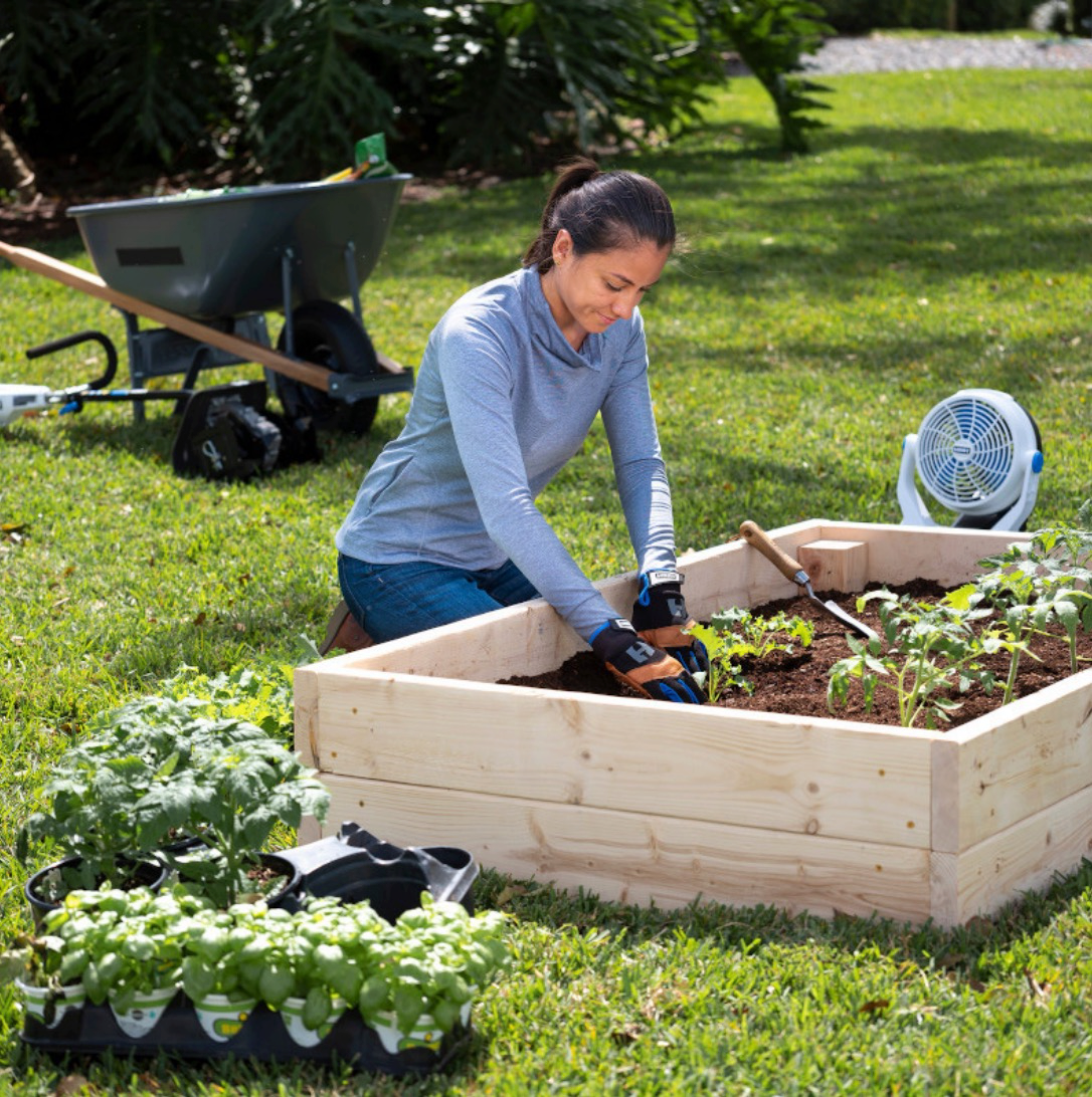 Woman planting in a raised garden bed