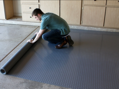 man rolling out garage floor mat.