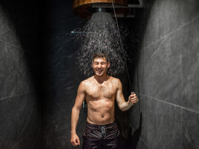 Man with bucket of ice cold water after hot sauna