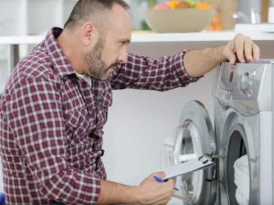 Repairman looking at washing machine