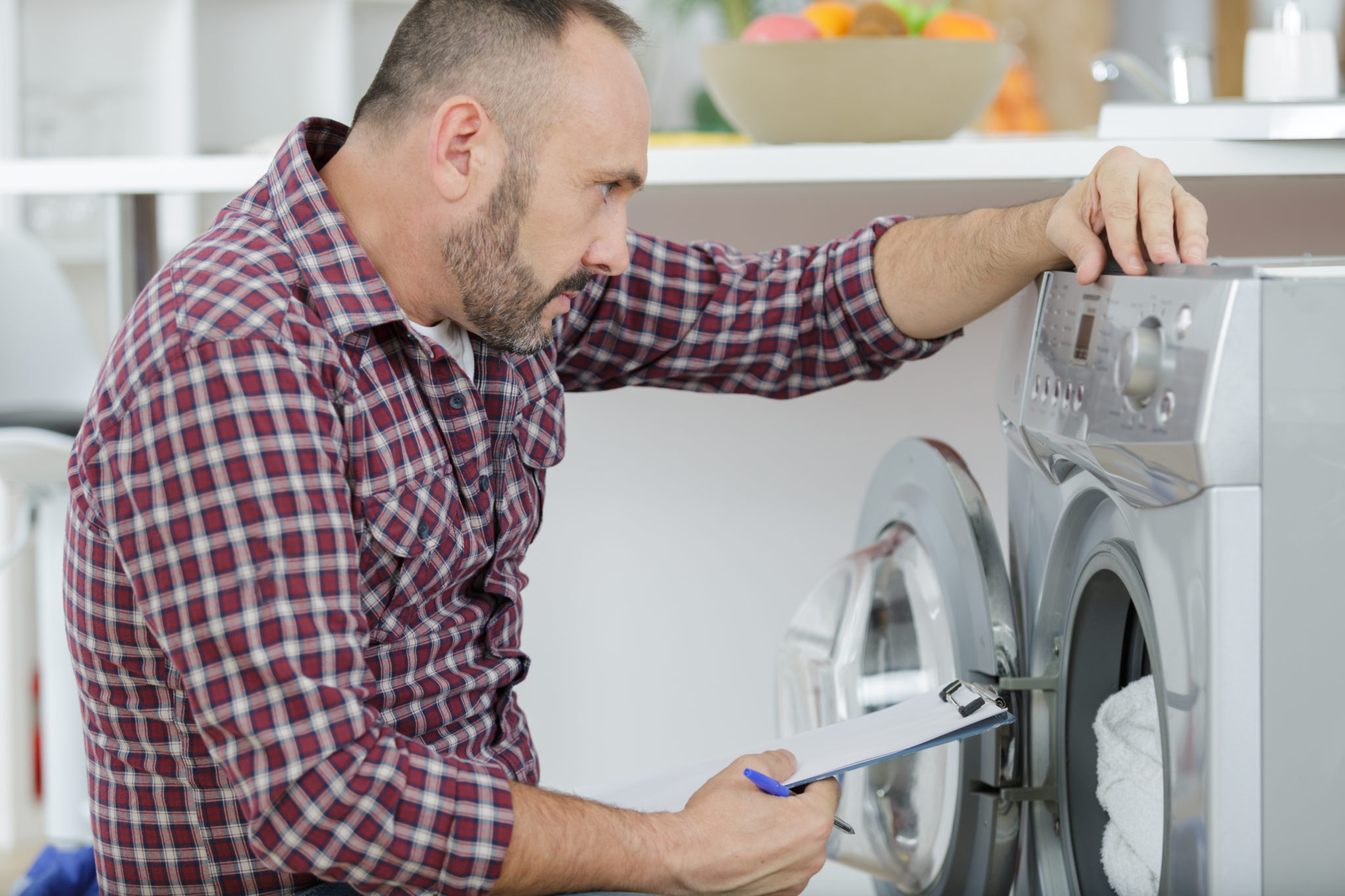 Repairman looking at washing machine