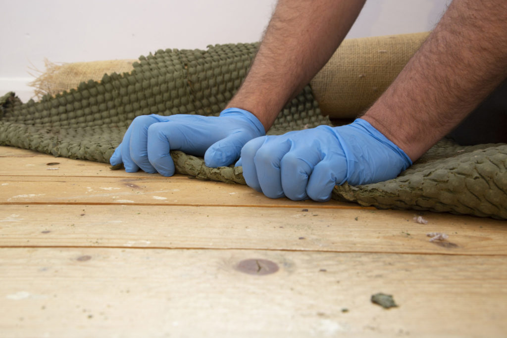 Man pulling up and removing carpet