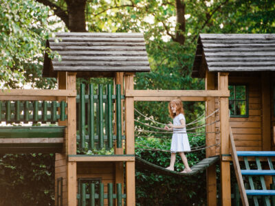 Child on wood play house above ground
