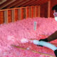 Man adding blowin in insulation to an attic