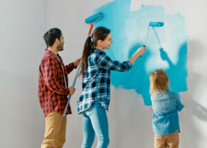 Mom, Dad and child all painting a wall