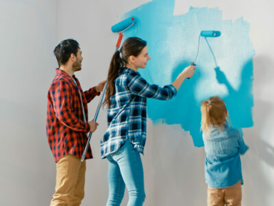Mom, Dad and child all painting a wall