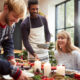 Group Of Friends Sitting Around Dining Table At Home As Christmas