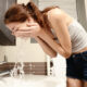 Woman in bathroom washing her face over the sink