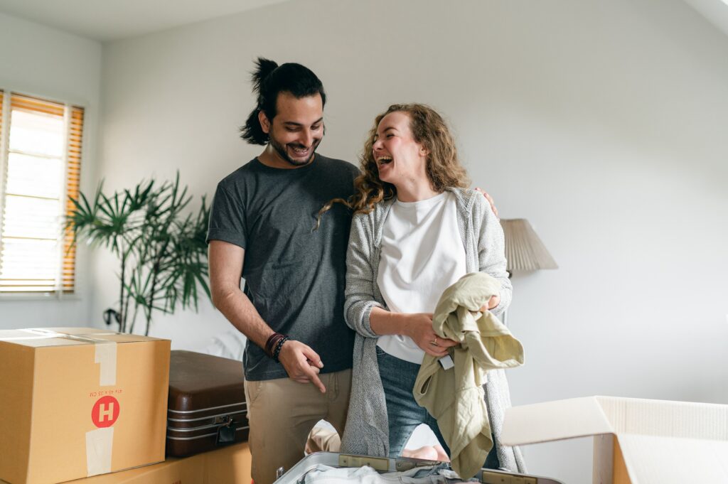 Couple unpacking boxes in a new apartment they rented