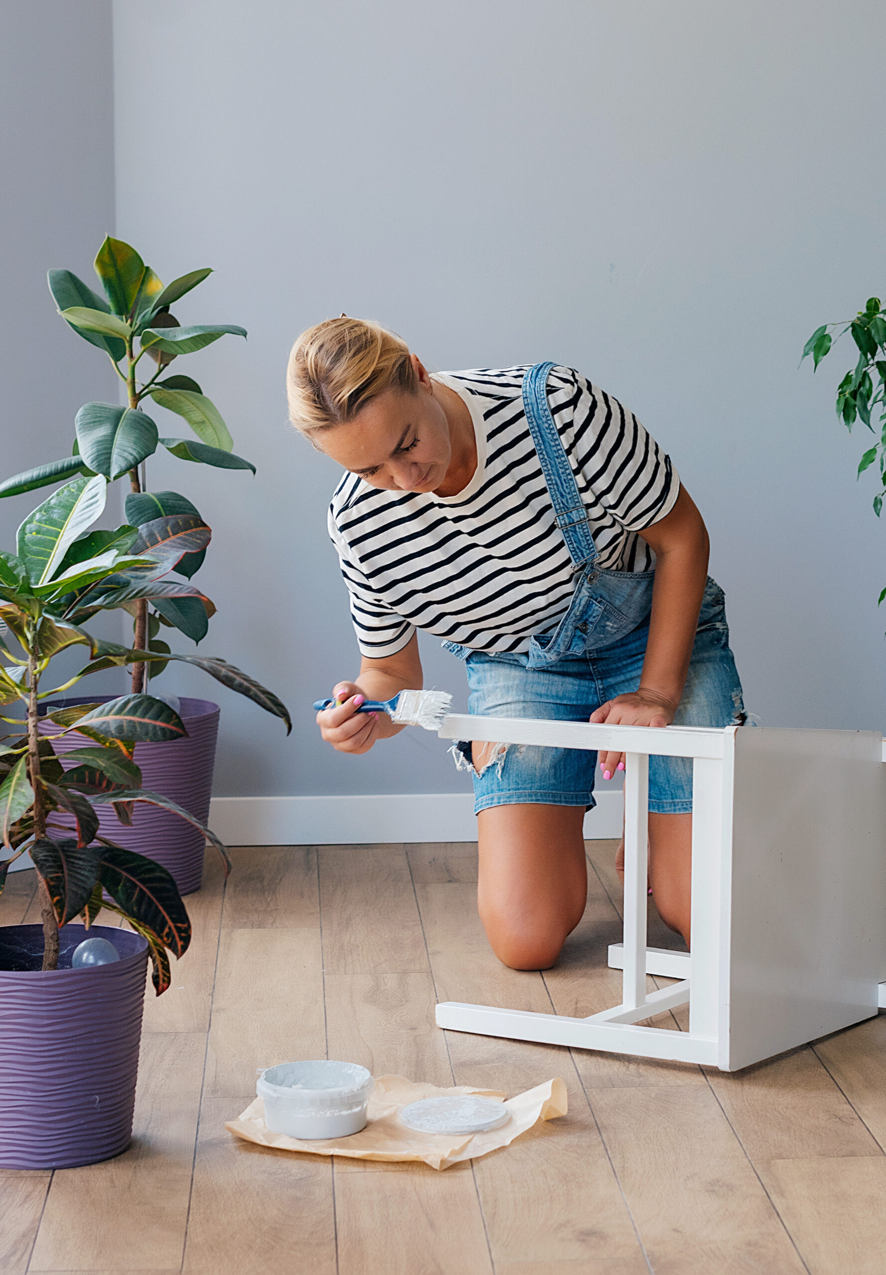 Woman at home painting a chair