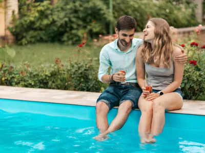 Couple sitting at the edge of a pool