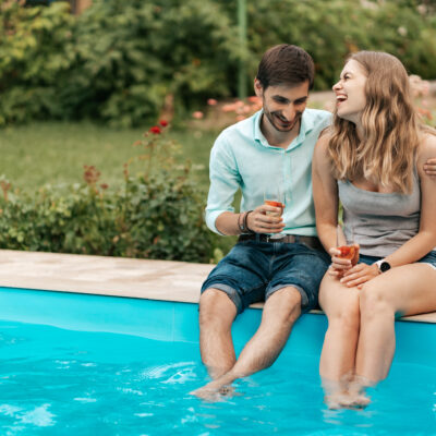 Couple sitting at the edge of a pool