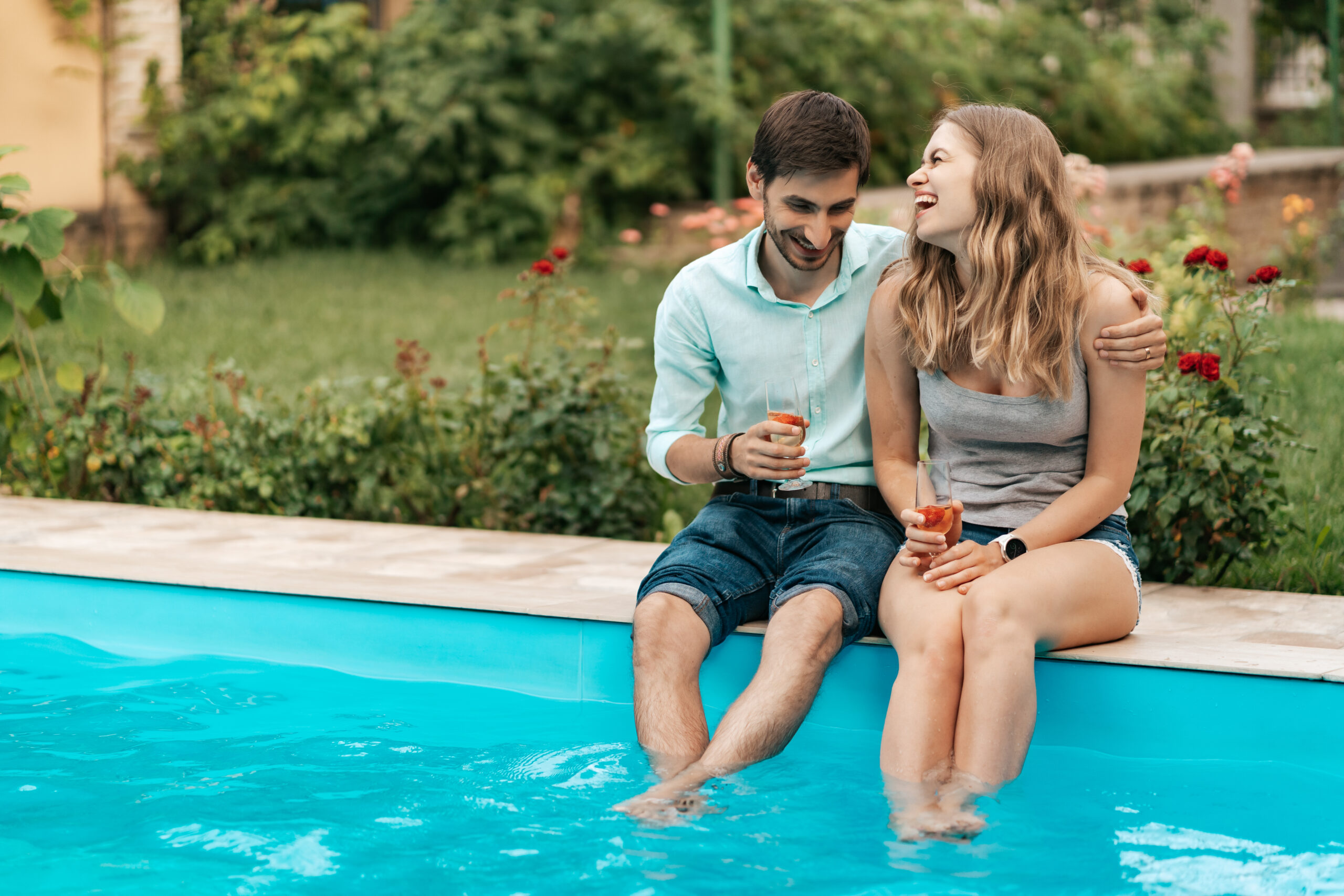 Couple sitting at the edge of a pool